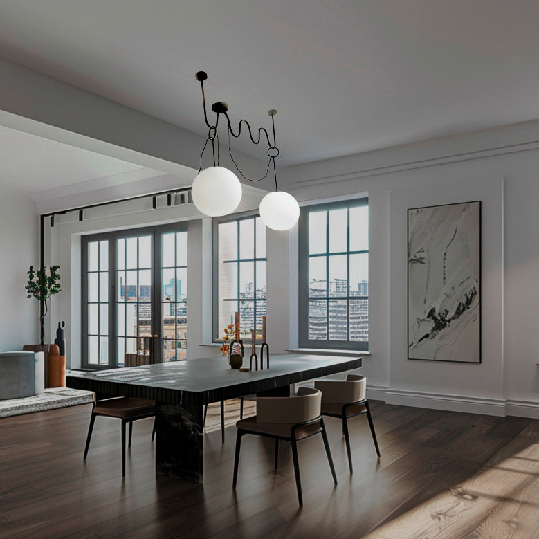 Lampada THUNDERGLASS sospesa sopra tavolo da pranzo in sala moderna open space, ottone nero e vetro Murano bianco.